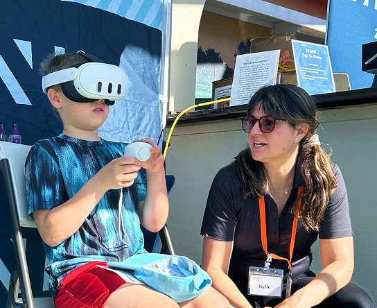 A Zenni team member guiding a child through a Zenni virtual reality experience.