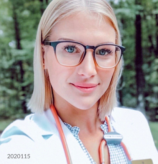 Image of a nurse wearing Zenni square glasses #2020115 standing in front of a row of trees.