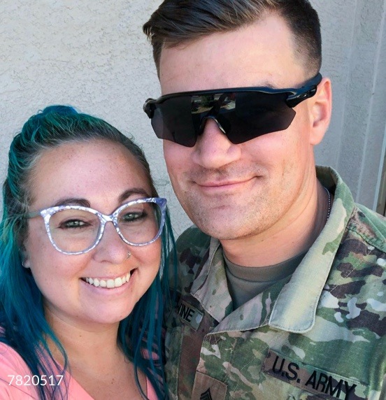 Image of a soldier and a lady wearing Zenni cat-eye glasses #7820517 in front of a white stucco wall.