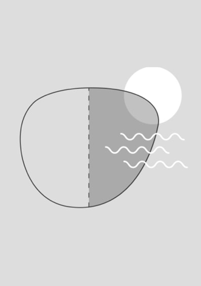 Image of a glasses lens with a sun emitted rays towards it. Half of the lens appears to be darkening from the rays.