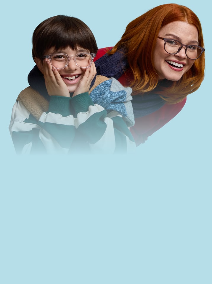 Smiling family with toddler wearing blue and yellow rectangle glasses, mom with purple and blue patterned glasses, dad with transparent glasses, and child with black rectangle glasses.
