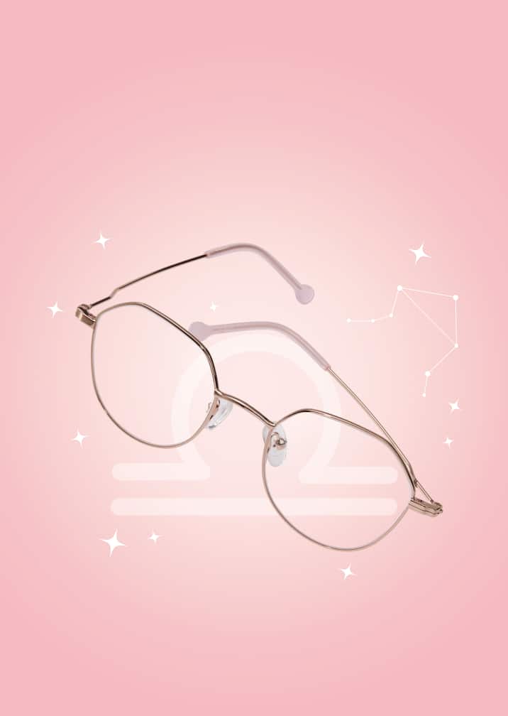 Rose-toned metal glasses with a modern silhouette on a pink zodiac background with the Libra symbol and constellation.