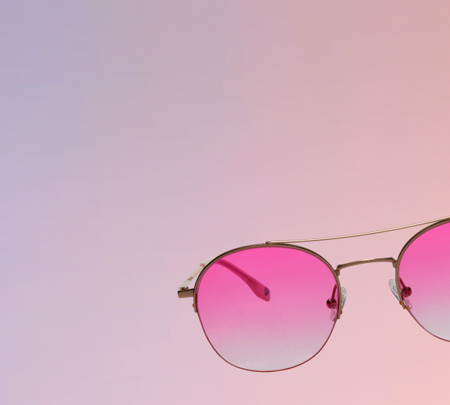 Close-up of Zenni pink round festival sunglasses against a pastel sky background.