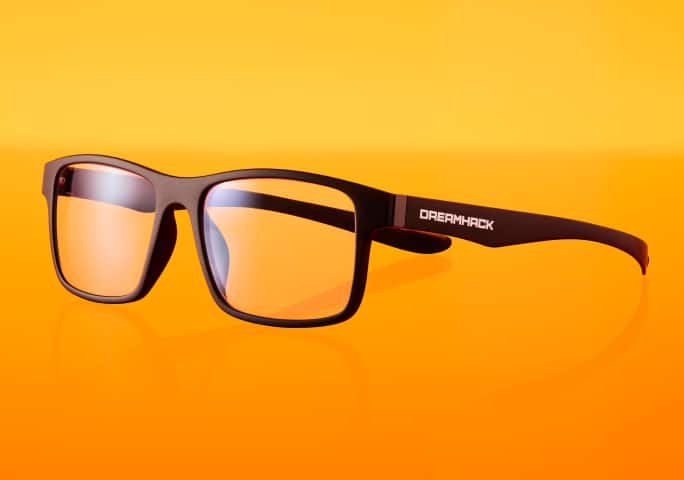 Black-framed Zenni x DreamHack glasses with clear lenses and black arms featuring 'DreamHack' printed in white, set against an orange background.