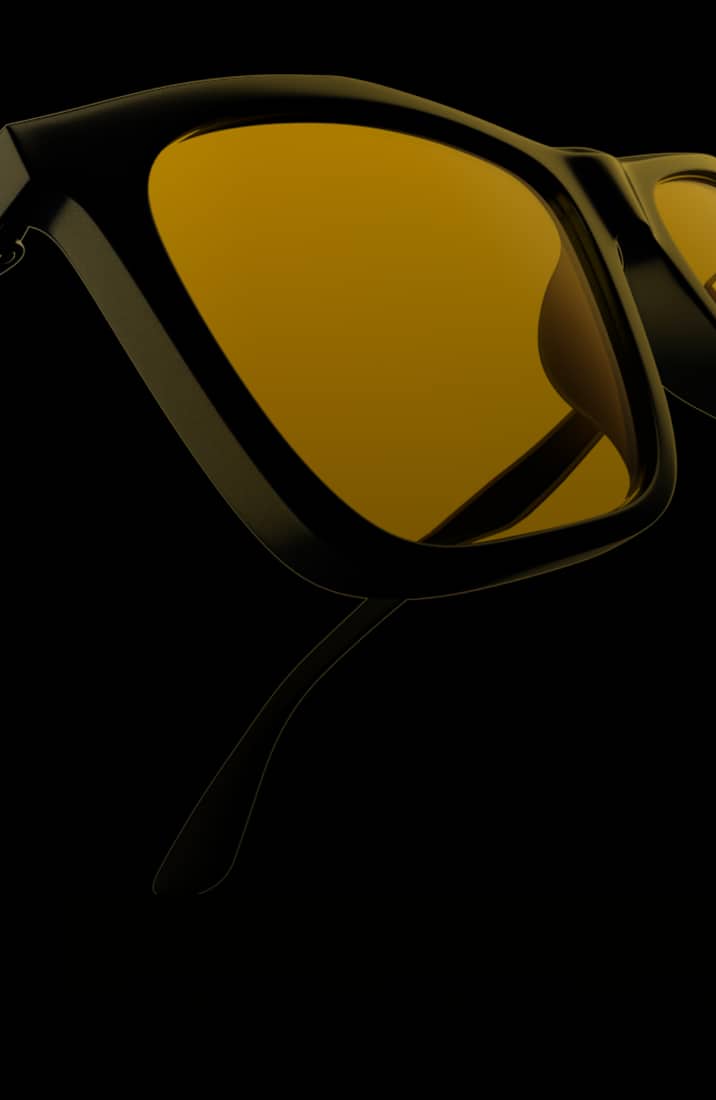 A mean with short buzzed hair wearing metal aviator glasses with yellow lenses.