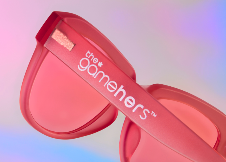 Close-up of Zenni's pink "the gamehers" glasses with pink tint lenses on a pastel gradient background.