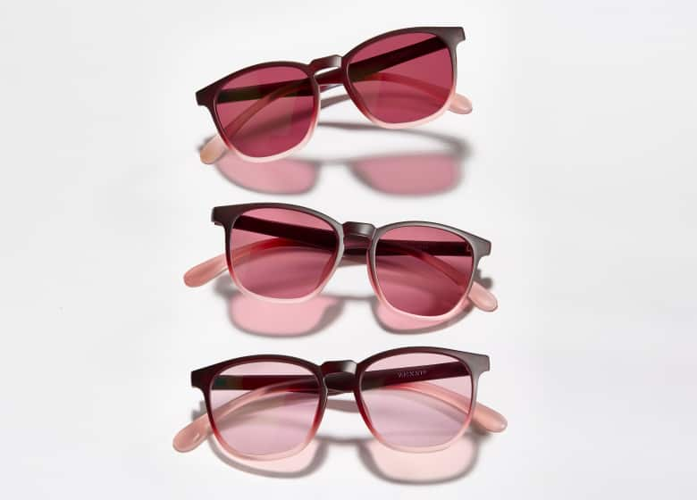 Three pairs of sunglasses with red lenses and pink arms, arranged vertically on a white background.