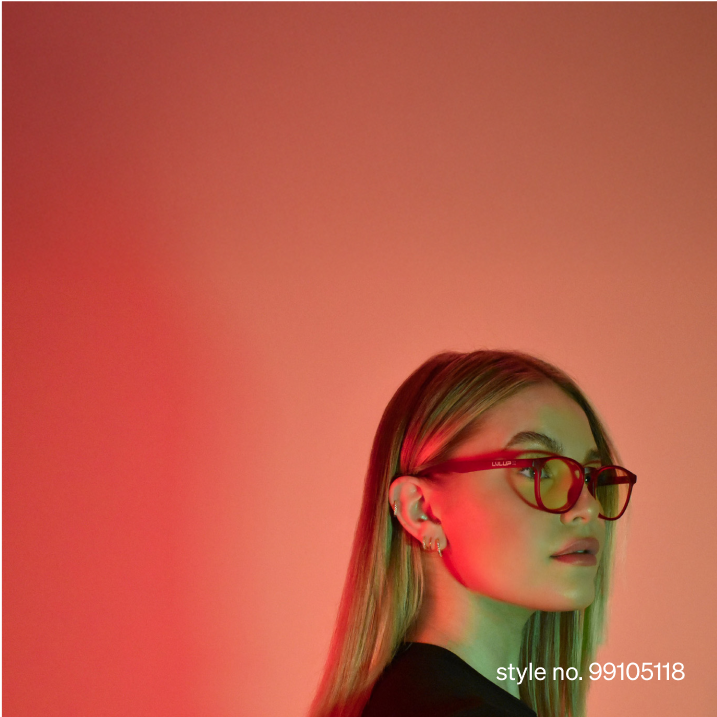 A woman with kong hair wearing square red LVLUP x Zenni glasses, with green lighting on an orange background.