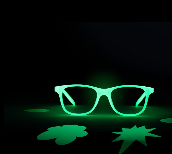 The image shows glowing green rectangular glasses centered against a dark background. Surrounding them are abstract green shapes, including an ellipse, a clover-like form, and a starburst, creating a striking contrast.