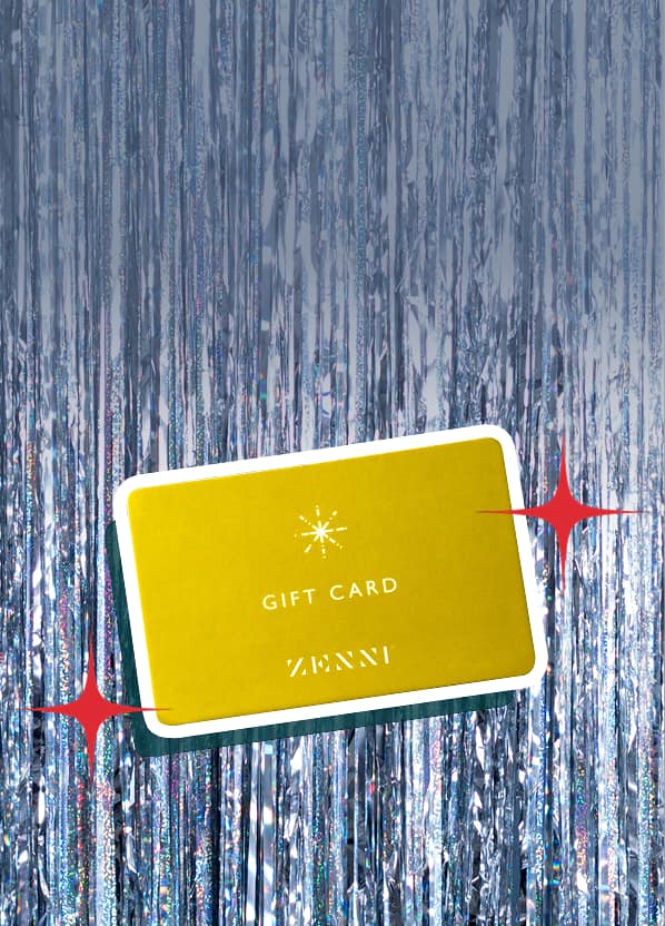 Gold Zenni gift card on silver tinsel background with illustrated red holiday stars