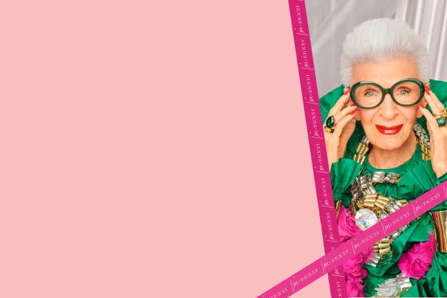 Image of Iris Apfel wearing oversized oval glasses against a silver curtain background.