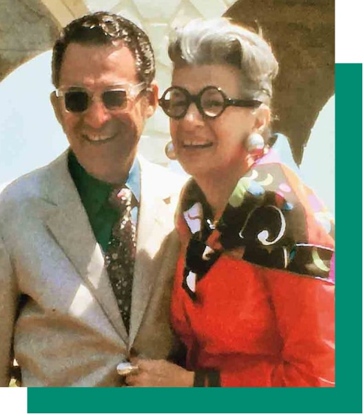 Image of Iris Apfel and her husband Carl from the 70s, both wearing glasses and posing together. 