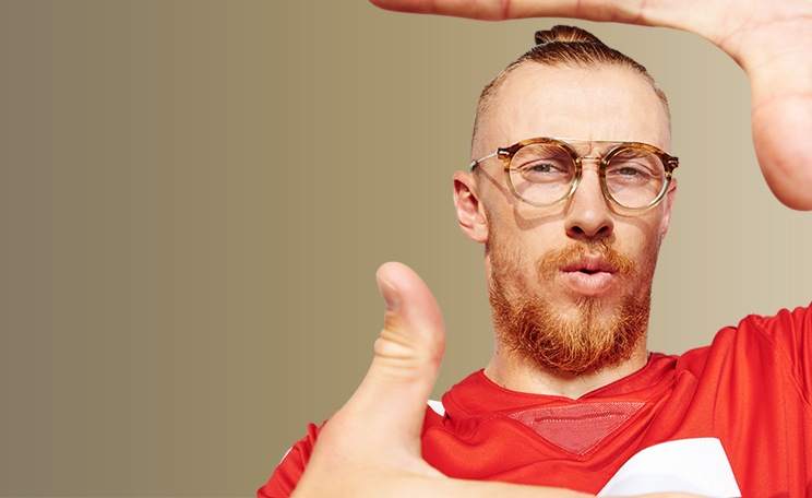 Image of George Kittle wearing Zenni the people’s frames round glasses #7826125 while framing the photo with both of his thumbs and forefingers.