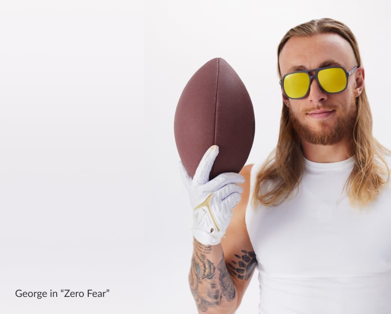 George Kittle, 49er, with long hair, holding a football, wearing yellow lens sunglasses and white tank, white background. (STYLE NAME & #1144812).