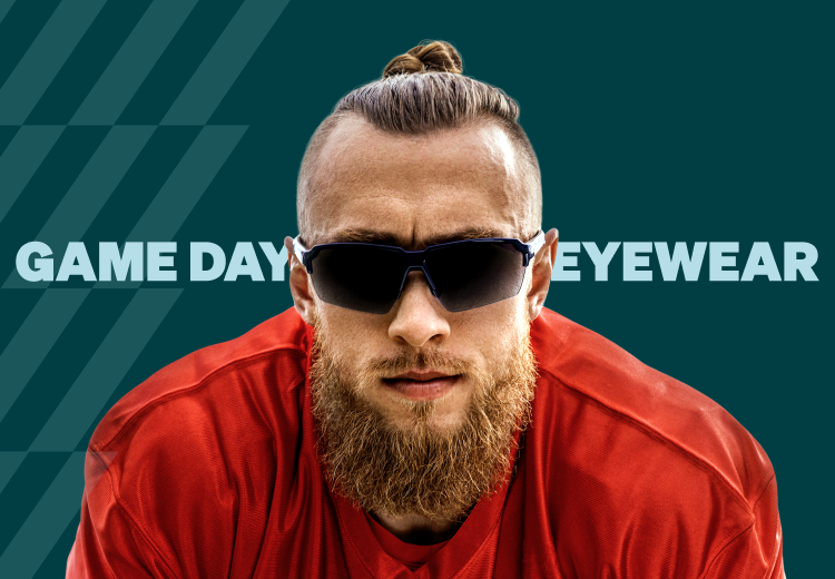 George Kittle in a pair of blue and black “Yay Area” Zenni sports performance sunglasses has his long hair slicked back in a bun wearing a red San Francisco 49ers football jersey against a dark teal geometric pattern background.