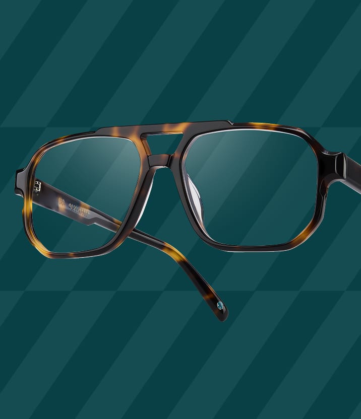 Close-up of tortoiseshell aviator-style Zenni glasses on a dark teal patterned background.