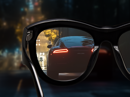 Cat-eye black glasses with nearly clear night driving lenses, reflecting a street at night where the LED tail lights are crisp with almost no glare.