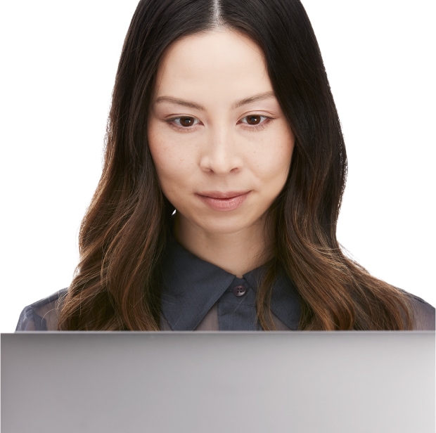 A woman looking straight down at a laptop monitor screen.