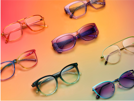 Colorful Zenni glasses from the Pride Collection arranged on a gradient background with soft rainbow tones.
