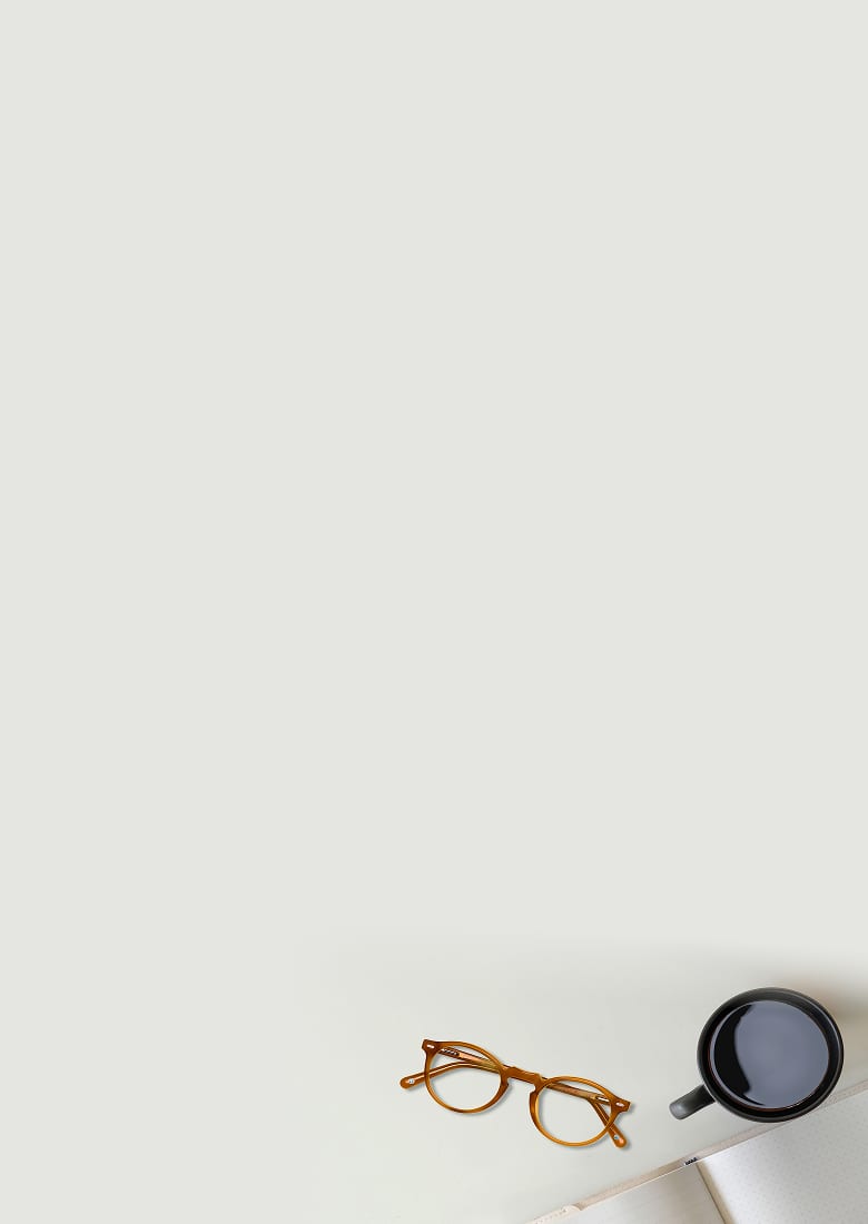 Classic browline glasses #194815 in brown on top of a notepad surrounded by books and a coffee mug. 