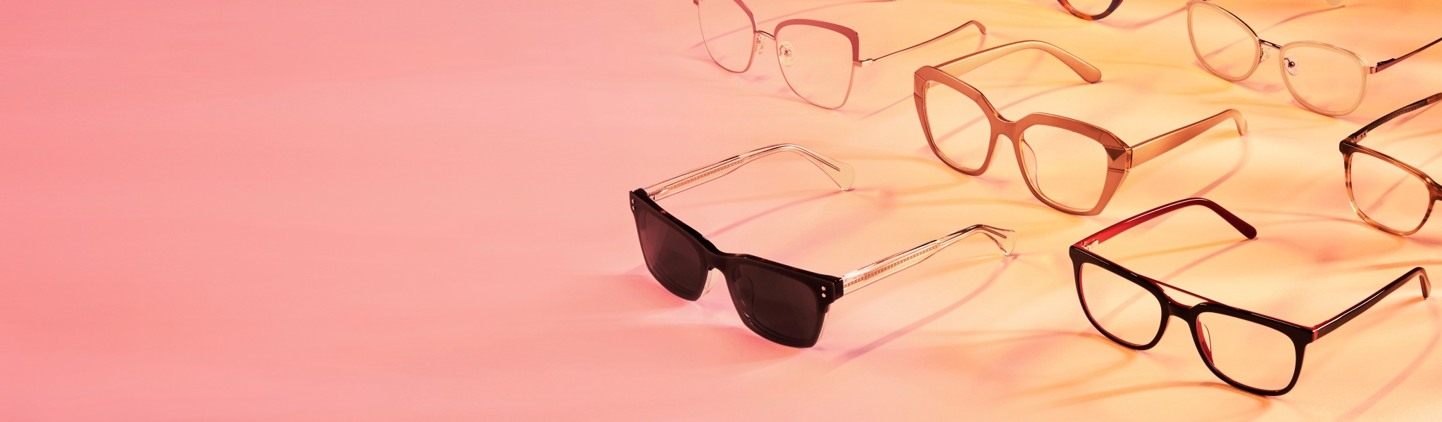 Image of several pairs of Zenni glasses against a peach-orange background.