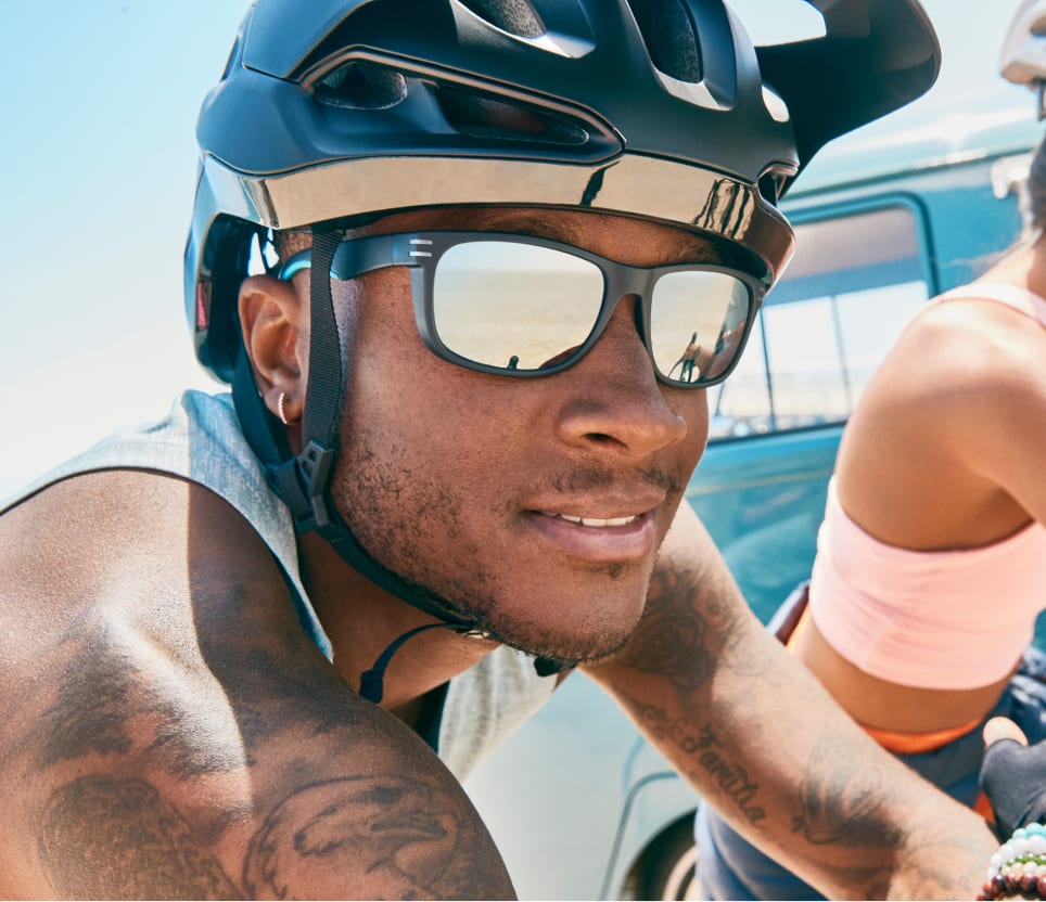 Image of a man wearing Zenni sports sunglasses while riding a bicycle.