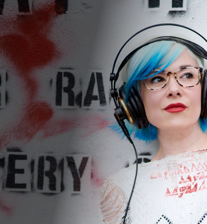 Image of a woman with blue hair wearing Zenni glasses and headphones, listening to music.