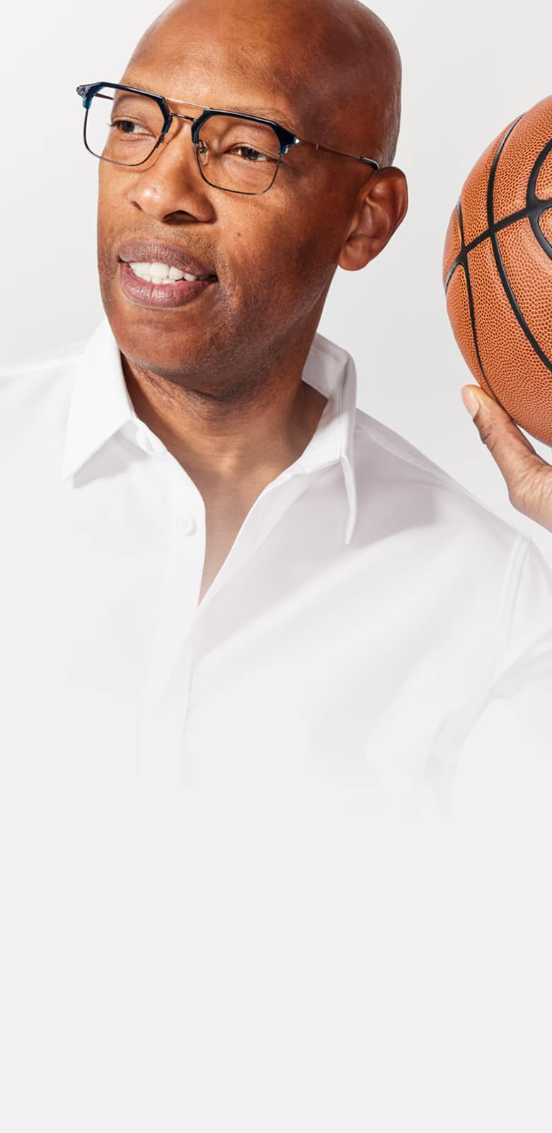 Sam Cassell wearing Zenni eyeglasses and a white collared shirt, holding a basketball.