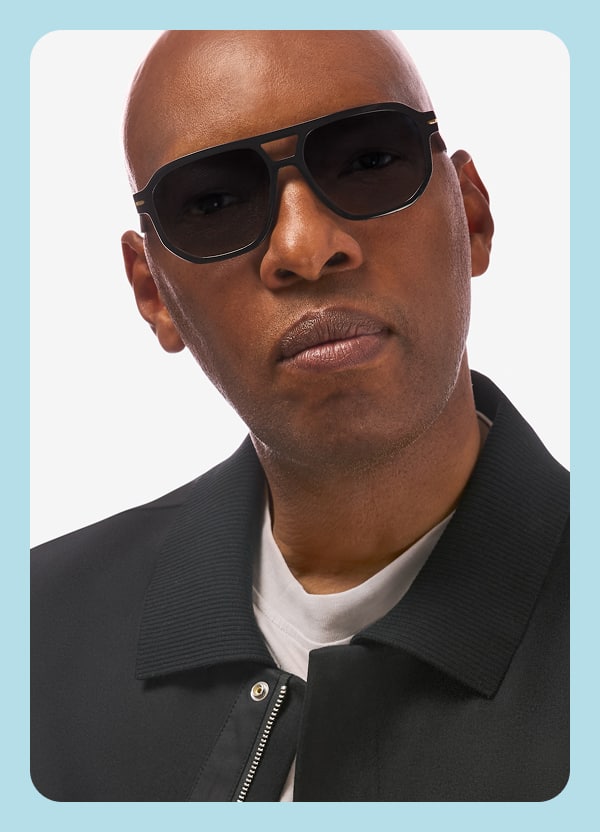 Sam Cassell wears black Zenni sunglasses, showcasing bold style and confidence from his Coach’s Collection.