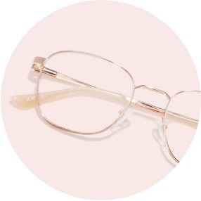 Image of a pair of rose gold metal square glasses against a light pink background.