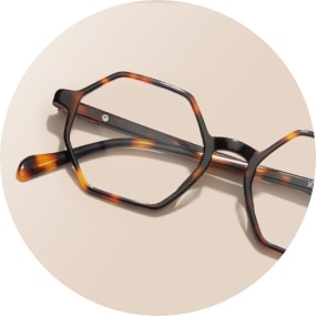 Image of a pair of tortoiseshell geometric glasses against a beige background.
