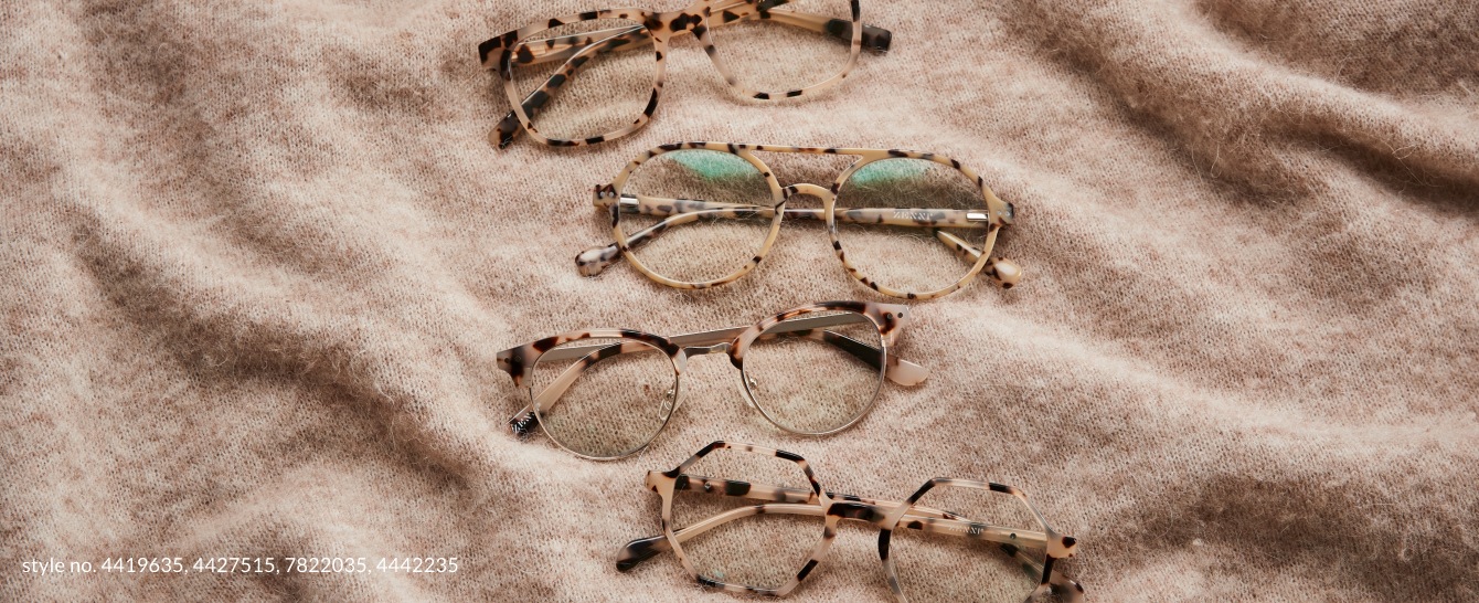 Image of 3 Zenni tortoiseshell glasses laying on a tan blanket.