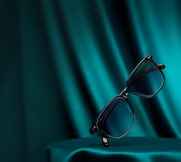 Teal frame Zenni sunglasses on a teal satin background.