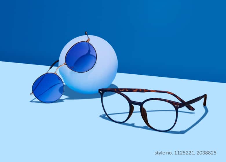 A pair of metal round sunglasses with blue lenses and a pair of round plastic eyeglasses.