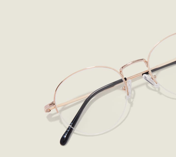Image of Zenni gold browline glasses style #3224114 shown with a light green background.