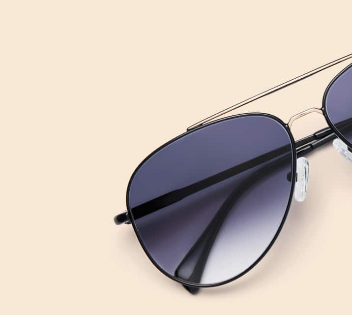 Image of Zenni black aviator style #1126721, shown with a gray gradient tint and a beige background.