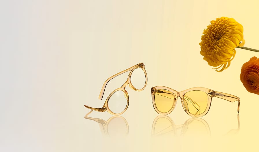 Two translucent yellow glasses style no. 4411522, 4466522 set on a gradient background with yellow flowers.