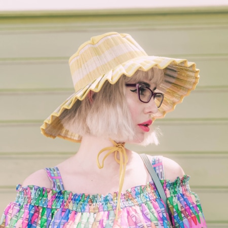 Amy Roiland wearing zenni cat-eye glasses #623017 in front of a folding green garage door.