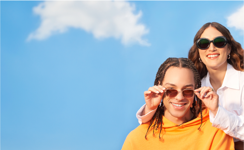 A man and woman in Zenni sunglasses with the blue sky as background.