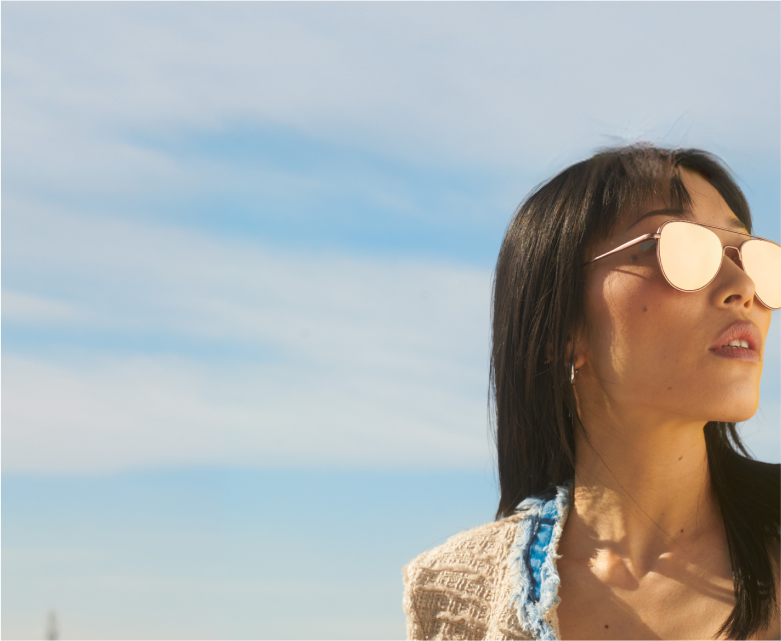Woman wearing aviator sunglasses with mirror tint.