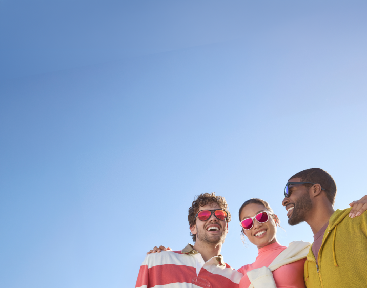 Three people in athletic clothes with their arms around each other. A man in black aviator sports sunglasses with red mirror lenses, a woman in white square sports sunglasses with pink mirror lenses, and a man in black square sports sunglasses with blue mirror lenses.