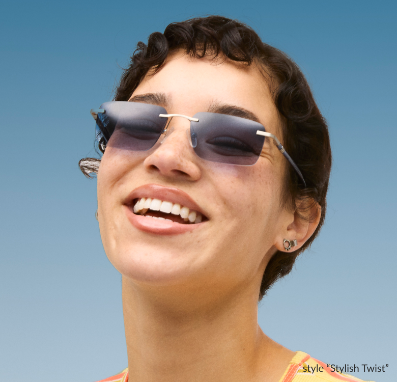 A woman with short curly hair is wearing rimless square “Stylish Twist” Timo x Zenni sunglasses and smiling against a blue background.