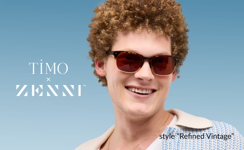 A man with curly hair wearing brown  browline sunglasses in style “Refined Vintage” by Timo x Zenni against a blue background.