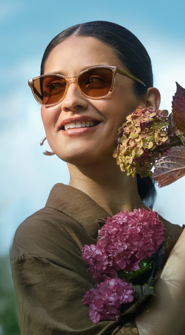 Brown rectangle Zenni sunglasses with tinted lenses worn by a smiling woman outdoors.