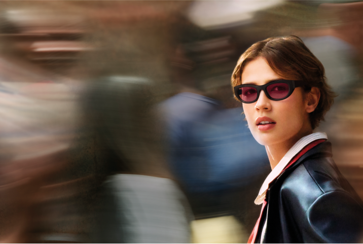 Three pairs of sunglasses sit on a light surface: one with a tortoiseshell cat-eye frame and amber lenses, one with pearl square frames and red lenses, and one with a marbled blue rectangular frame and blue lenses.