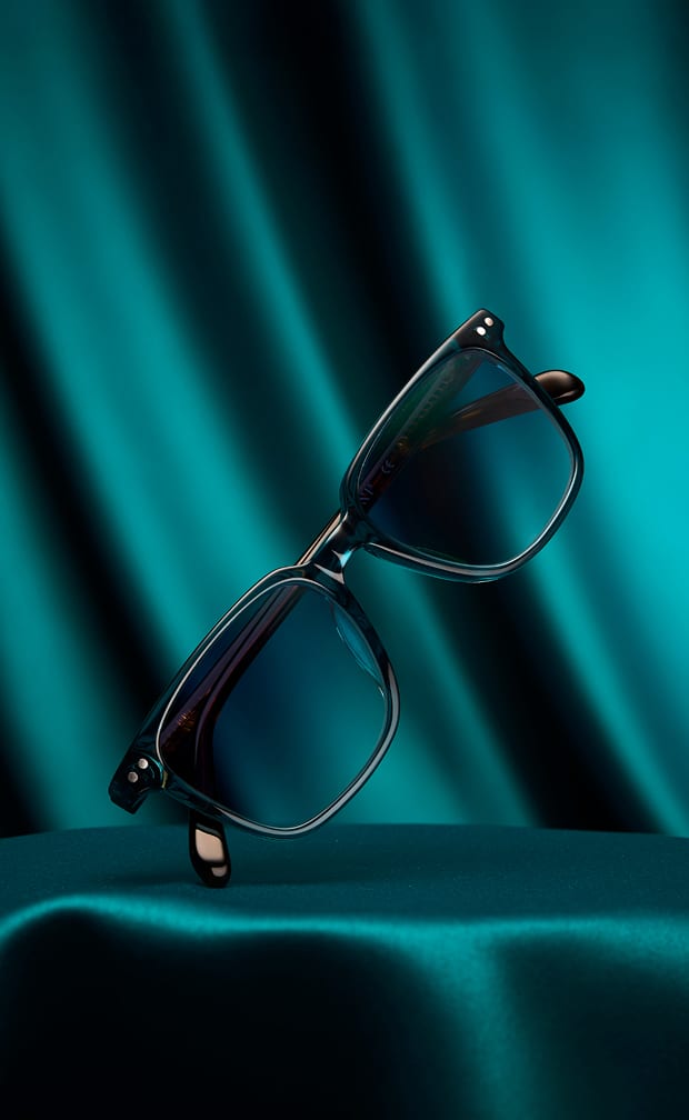 Teal frame Zenni sunglasses on a teal satin background.