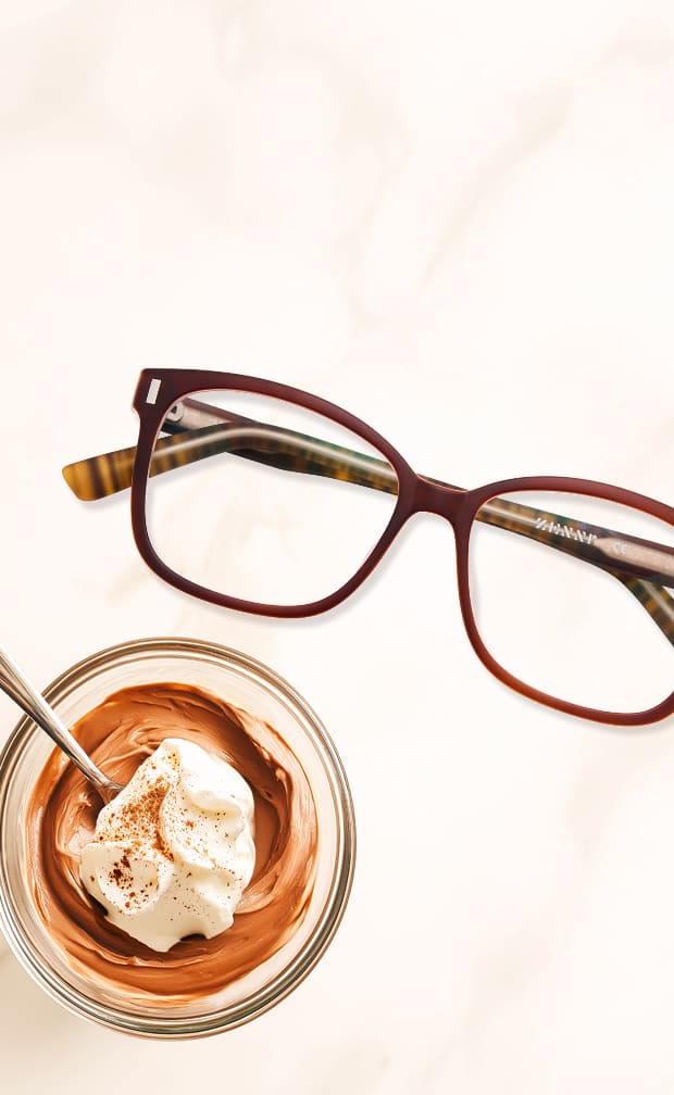 Brown Zenni metal-rimmed glasses with gold accents on a beige background.