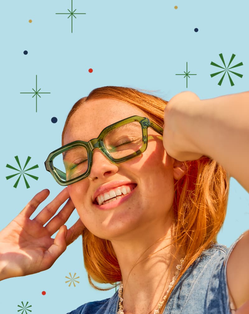 Red-haired woman wearing Zenni green translucent oversized glasses with a sky-blue background and festive abstract shapes.