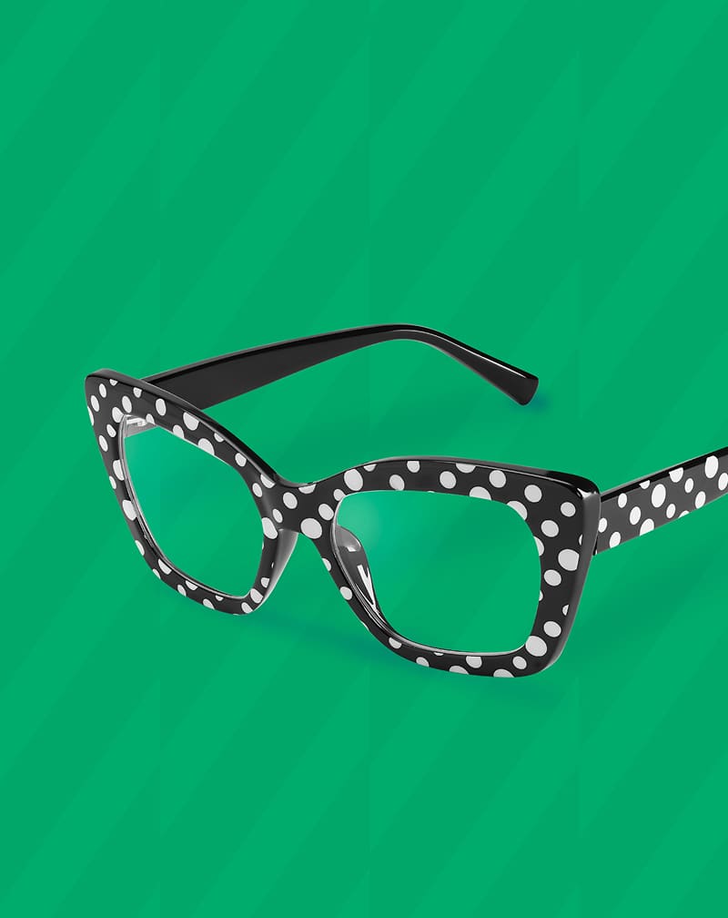 Zenni cat-eye rectangular glasses with black and white polka dots displayed on a green textured background.