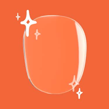A clear Trivex lens on a red background, with illustrated sparkles in the corner to indicate superior clarity.